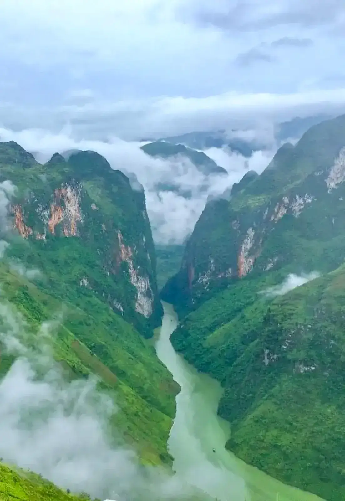 Motorbike riders traveling through the massive karst limestone loops in Ha Giang, Vietnam